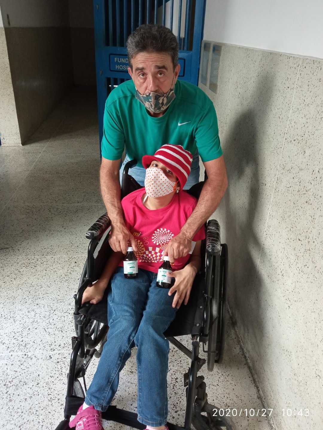 A Girl in Wheelchair with Relieved Father Holding Anticonvulsant